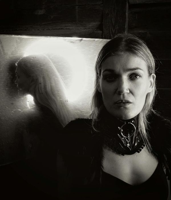 Woman in a relaxed, flowing pose against a dark background with honey-colored light.